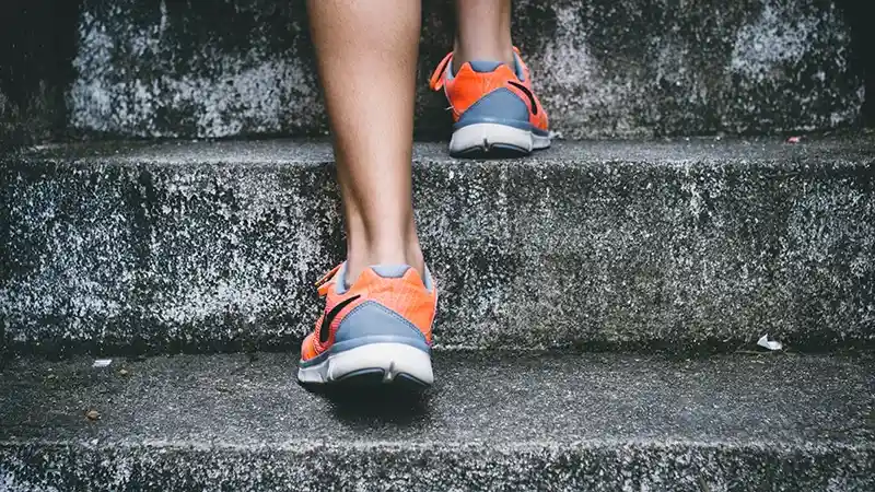 content strategy steps person with running shoes climbing stairs